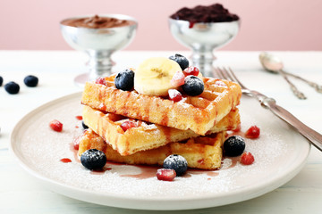  waffle con frutta e sciroppo su tavolo di cucina sfondo rosa