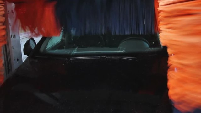 T&uacute;nel de Lavado de Coches Autom&aacute;tico - Procesos en la secuencia completa del  Lavado de un coche de color negro - Rodillos girando en el proceso de lavar y abrillantar el coche
