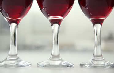 Glasses of red wine on white table closeup