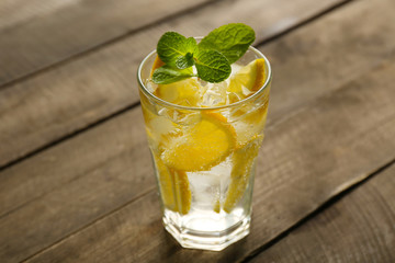 Lemonade with lemon and mint on wooden table background