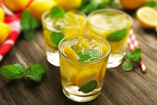 Composition of lemonades,  lemons and mint on wooden table background, closeup