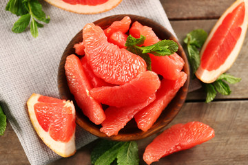 Juicy grapefruit pieces with fresh mint in a bowl, close up