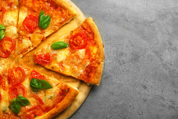 Sliced Margherita pizza on grey background