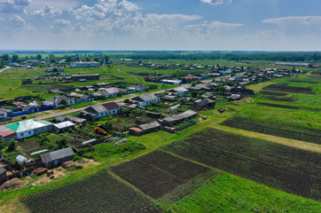 Novikova, Russia - June 18, 2015: Aerial view onto village of Novikovo and fields set with potato