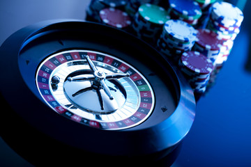 casino theme, high contrast image of casino roulette, playing chips and dice