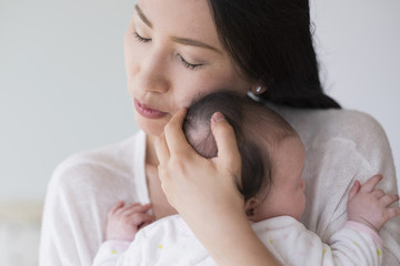 Asian mother hugging baby