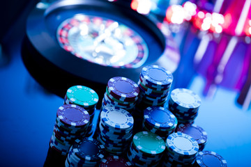 casino theme, high contrast image of casino roulette, playing chips and dice