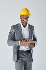 Smiling portrait of black engineer surveyor wearing construction hat
 