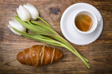 Obraz na płótnie Canvas coffee, croissant and three white tulips for spring breakfast