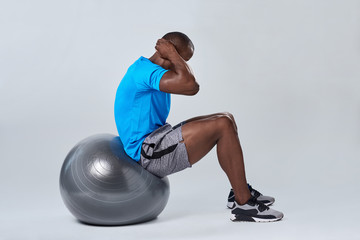 man doing sit up crunches exercise routine on gym ball