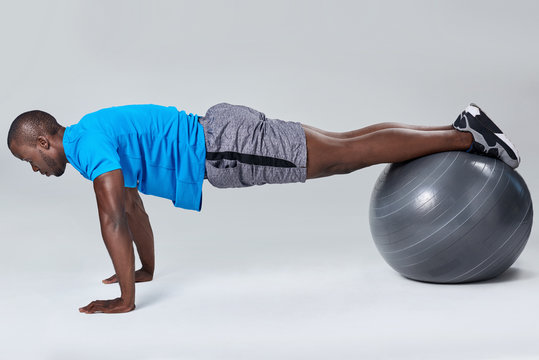 Man Doing Push Up Exercise Routine On Gym Ball