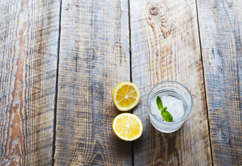 Lemonade with fresh lemon and mint on wooden background