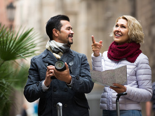 tourists with map and luggage on city street