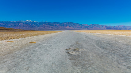 Fototapeta na wymiar Scenic view of salt planes. The bottom of the dried-up salt sea. The bark of salt. Badwater Salt Flat, Death Valley National Park