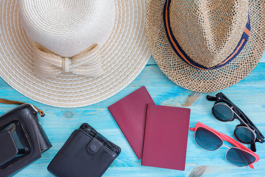 Summer hats  and other travel accessories on blue wooden backgro
