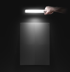 Hand holding lamp near the wall with blank poster mockup, isolated. Idea, night club event poster party design preview presentation. Wall mock up in light. Person hold torch in hands illuminate. 