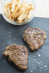 cooked beef chateaubriand steak with chunk chipped potatoes on p