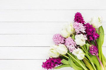 Bouquet of pink hyacinth flowers and white tulips on white wooden background. Top view, copy space 