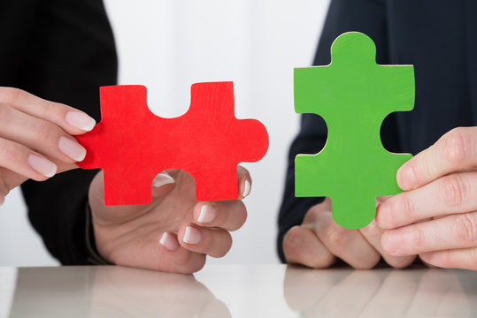 Businessperson Hand Holding Puzzle Pieces