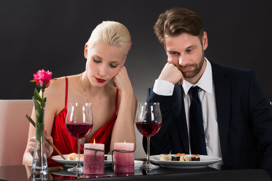 Sad Couple Having Dinner At A Restaurant