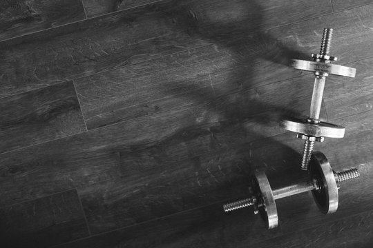Top view of a dumbells on a wooden background in a gym, healthz