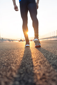 feet of an athlete running on a park pathway training for fitnes
