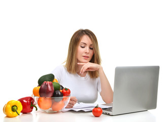 Confident nutritionist woman working at desk with fresh fruits a