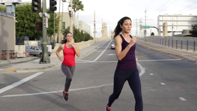Courageous strong women urban fitness run jog through a road closed construction site 