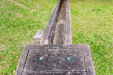 The concrete drainage tank and gutter beside lawns