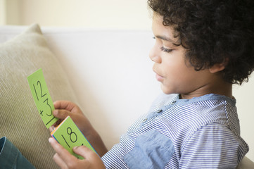 Mixed race boy using flash cards to study math