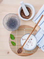 Nutritious flax seeds with glass of greek yogurt and wooden spoo