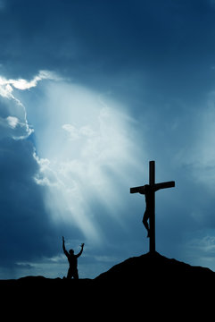 Dramatic sky scenery with cross and a worshiper vertical image
