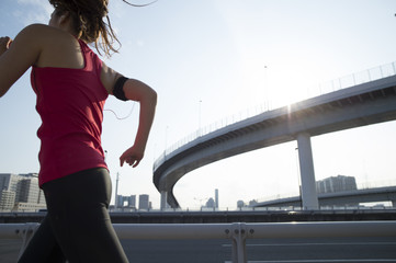 Woman runner is running the city with a wearable terminal