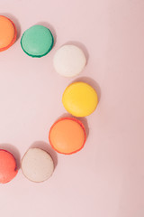 Colorful france macarons on pink background - copy space