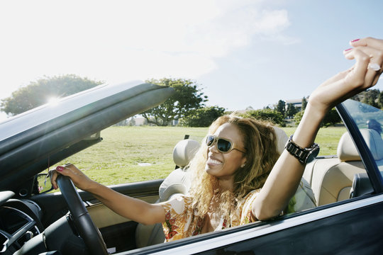 Mixed race woman driving convertible