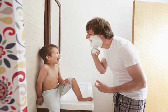 Father Teaching Son To Shave In Bathroom