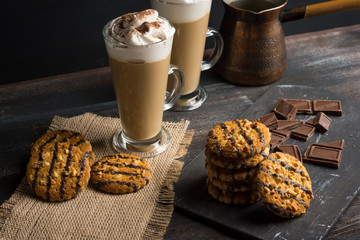 Glass of coffee with cookies on wooden background