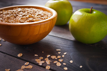Oat flakes in bowl and two apples