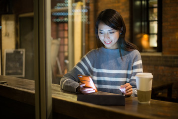 Woman use of tablet pc at night in cafe