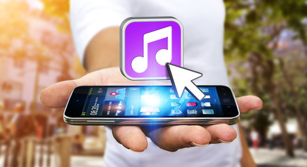 Young man using modern mobile phone to listen music