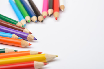 Close up picture of many little colored pencil crayons on white