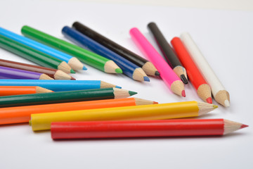 Close up picture of many little colored pencil crayons on white