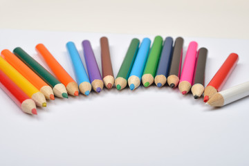 Close up picture of many little colored pencil crayons on white