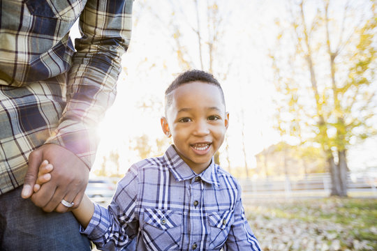 Father and son walking in autumn leaves