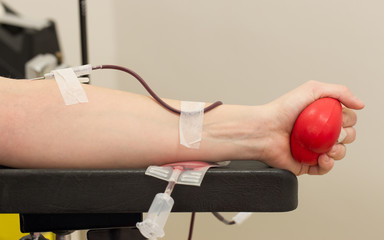 Donor in an armchair donates blood,, close-up