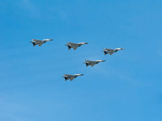 5 Mikoyan-Gurevich MiG-29SMT (Fulcrum) jet fighter aircrafts fly on blue sky background
