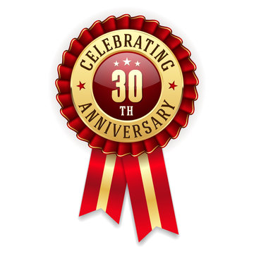 Gold 30th anniversary badge, rosette with red ribbon on white background