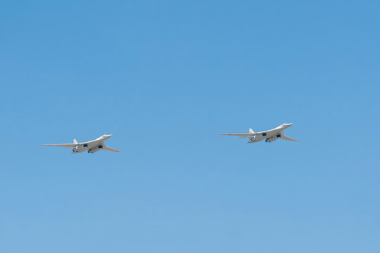 2 Tupolev Tu-160 (Blackjack) supersonic variable-sweep wing heavy strategic bomber fly on blue sky background
