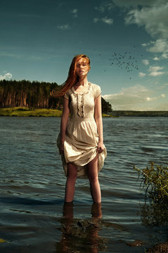 Caucasian woman standing in remote lake