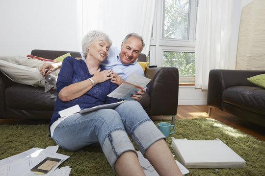 Older Couple Looking At Photographs In Living Room